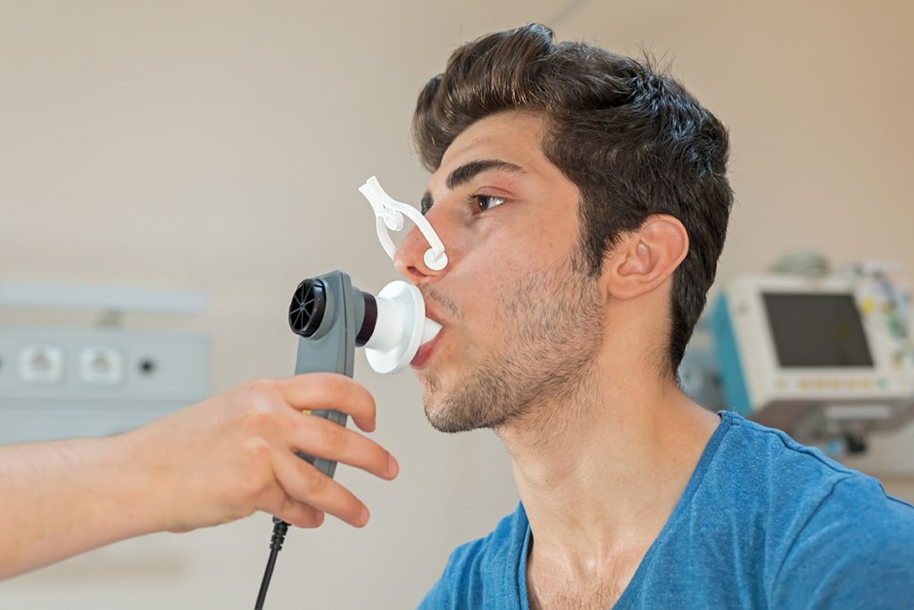 Profissional acompanhando um paciente durante um exame de espirometria